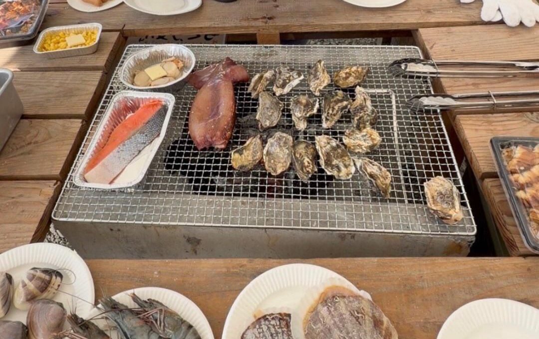 炭火の網に並ぶ牡蠣と海鮮